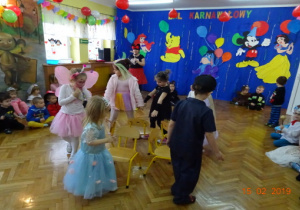 Dzieci tańczące wokół krzesełek.